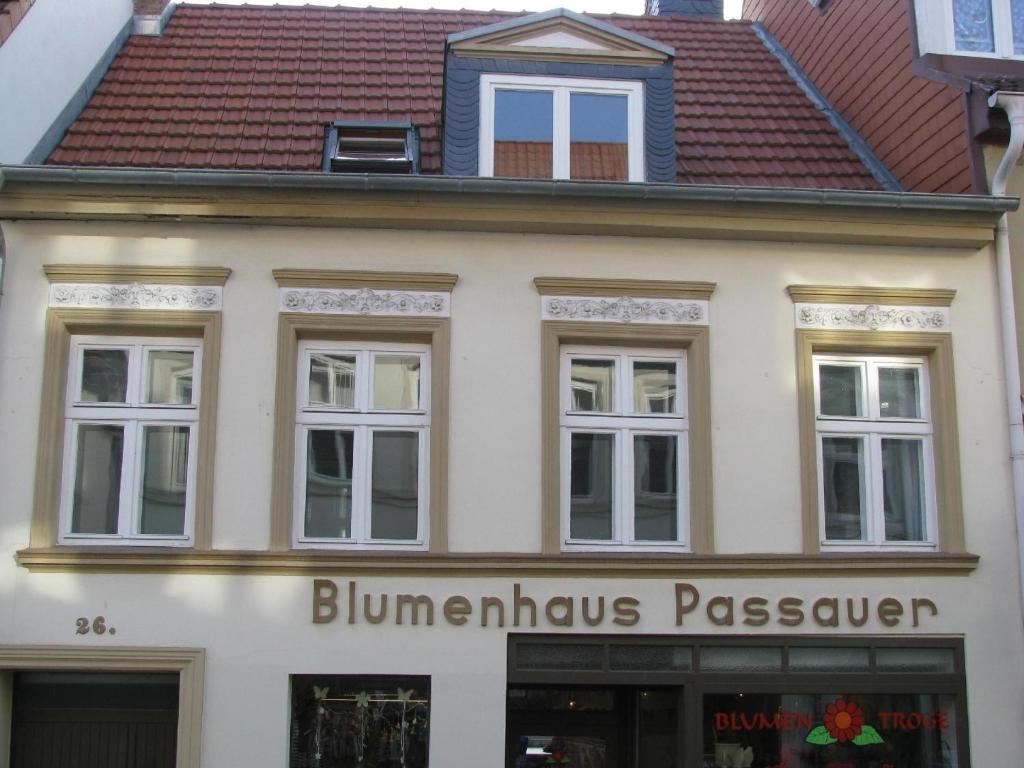 een wit gebouw met een bord voor een winkel bij Moderne Ferienwohnung mitten in der Greifswalder Innenstadt in Greifswald