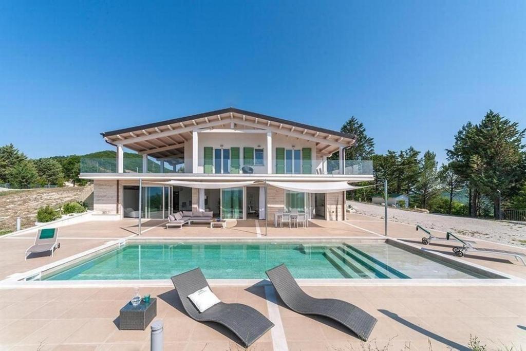 uma casa grande com uma piscina em frente em Nettes Ferienhaus in Acqualagna mit Großem Garten em Acqualagna