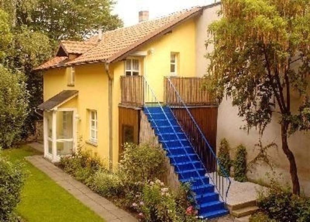 una casa amarilla con escaleras azules delante en Ferienhaus für 4 Personen ca 55 qm in Bamberg, Bayern Franken en Bamberg