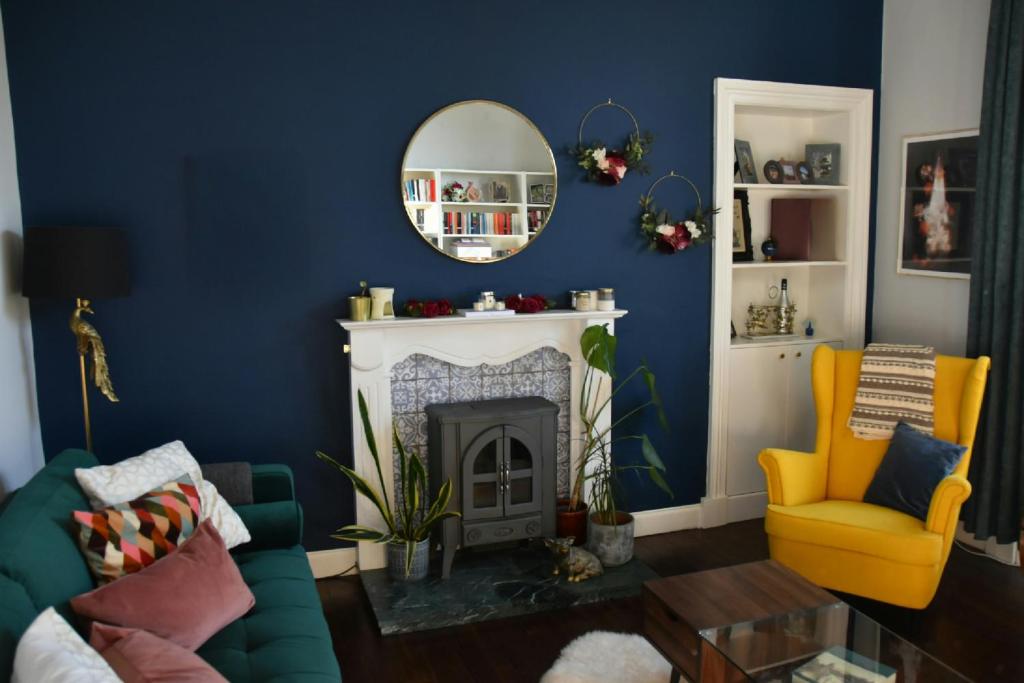 a living room with a fireplace and a mirror at Vibrant 1BD flat with Garden in Dunfermline, Fife in Dunfermline