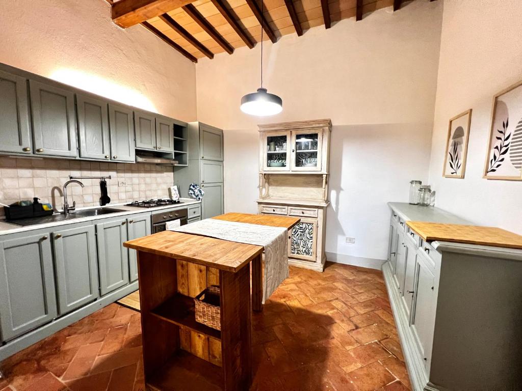a kitchen with gray cabinets and a wooden counter top at Casa ROMA21 in Buonconvento
