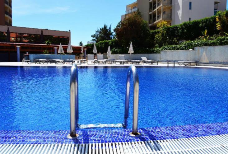 een zwembad met blauw water in een gebouw bij Sofiamarholidays - Casa Praia Mar in Portimão