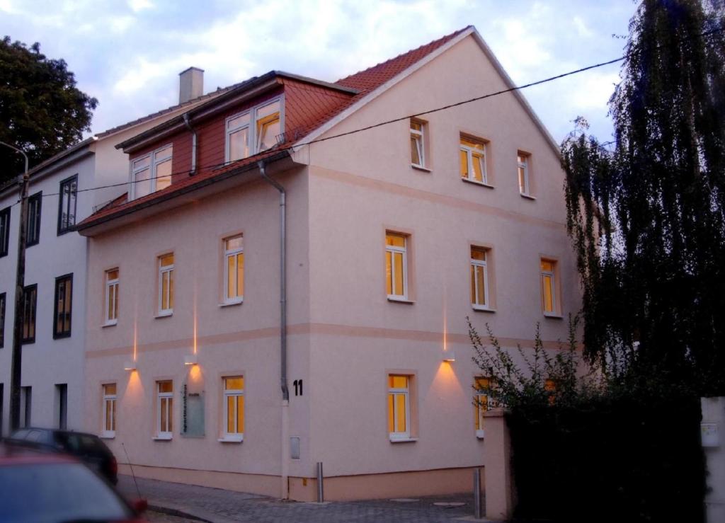 uma grande casa branca com luzes em Moderne Ferienwohnung in zentraler aber ruhiger Lage, in der Nähe des Szeneviertels Dresden-Neustadt em Dresden