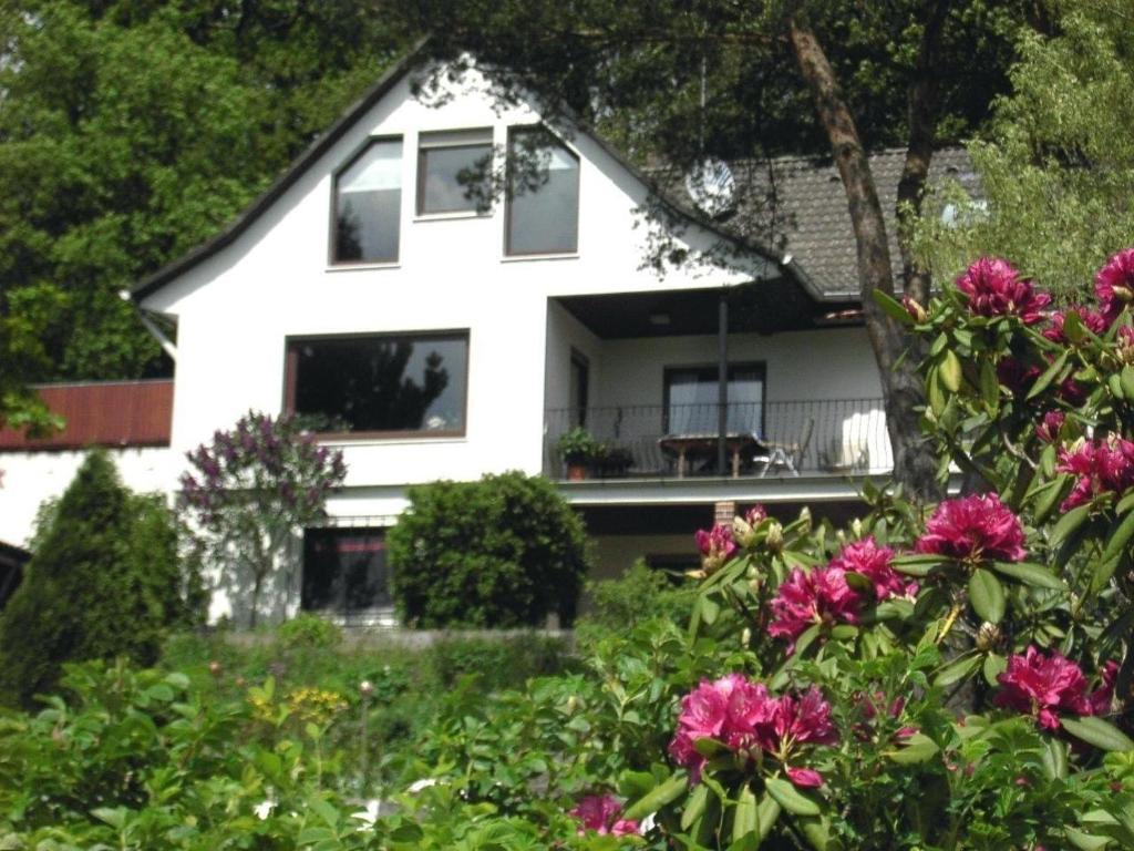 a white house with flowers in front of it at Ferienhaus in Obernsees mit Garten, Terrasse und Grill in Mistelgau
