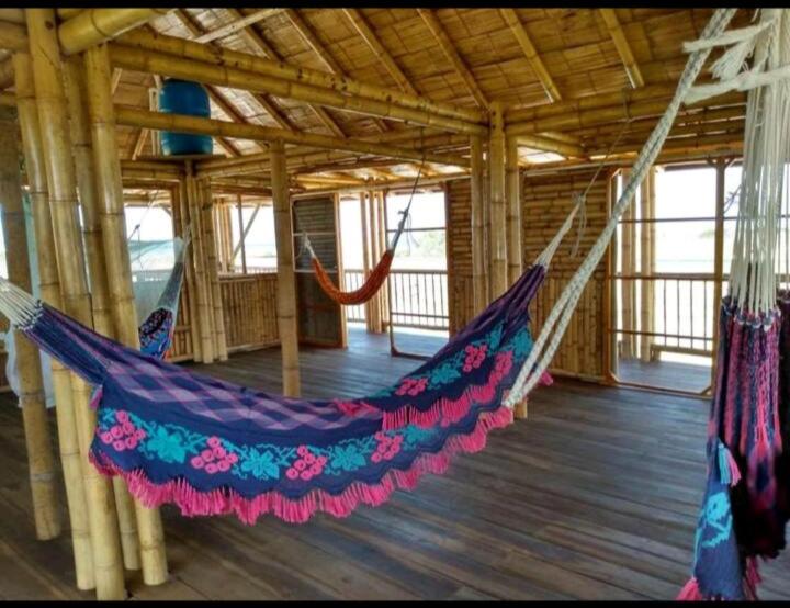 a hammock in a building with a wooden floor at Casa Coral in Mayapo