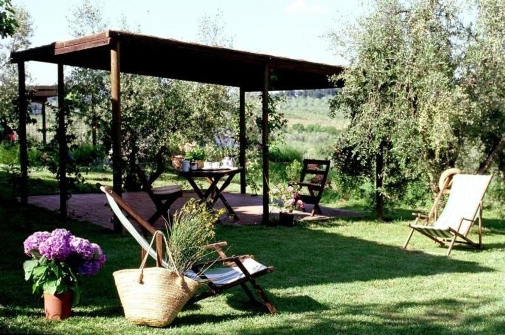 een tuinhuisje met een picknicktafel en stoelen in de tuin bij Ferienwohnung in Barberino Tavarnelle mit Privatem Garten - b58103 in San Donato in Poggio