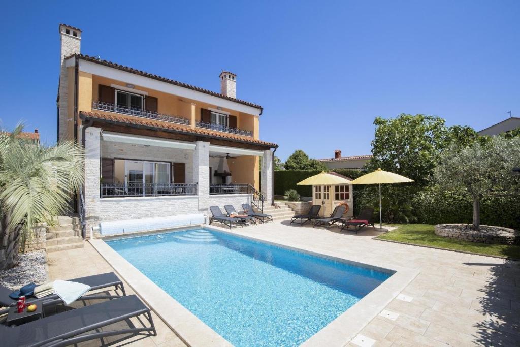 uma piscina em frente a uma casa em Ferienhaus in Pomer mit privatem beheizten Pool und Meerblick em Pomer