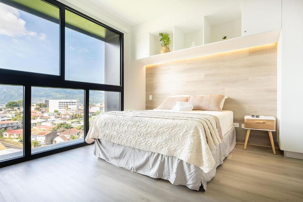 a bedroom with a bed and a large window at Brand new 1 bed loft with spectacular city view in El Empalme