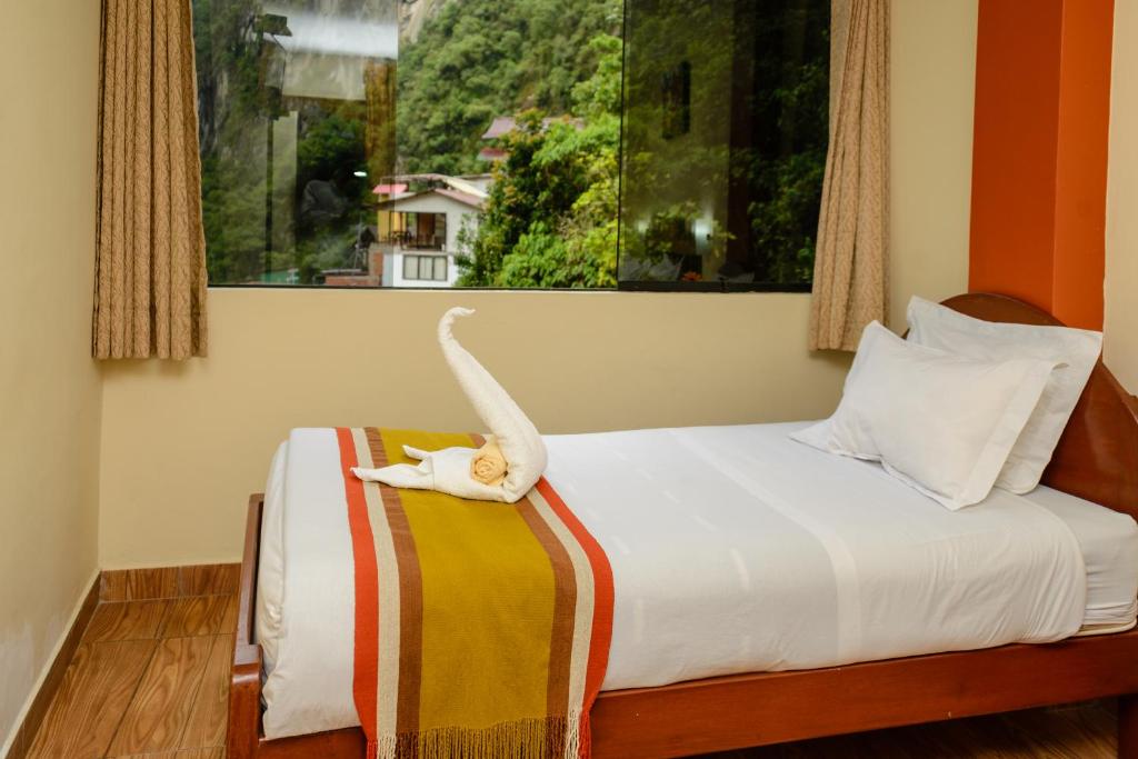 a cat laying on a bed in a room at Vista Waynapata 1 23 in Machu Picchu