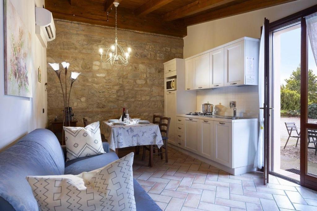 a living room with a kitchen and a table with a blue couch at Appartement in Scandiano mit Privatem Parkplatz in Scandiano