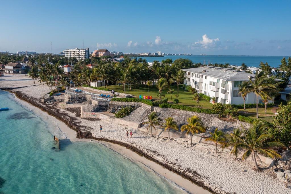 Hotel Dos Playas Faranda Cancún في كانكون: اطلالة جوية على شاطئ فيه نخل ومبنى