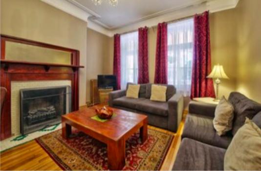 a living room with a couch and a fireplace at Les Maisons Montcalm in Quebec City