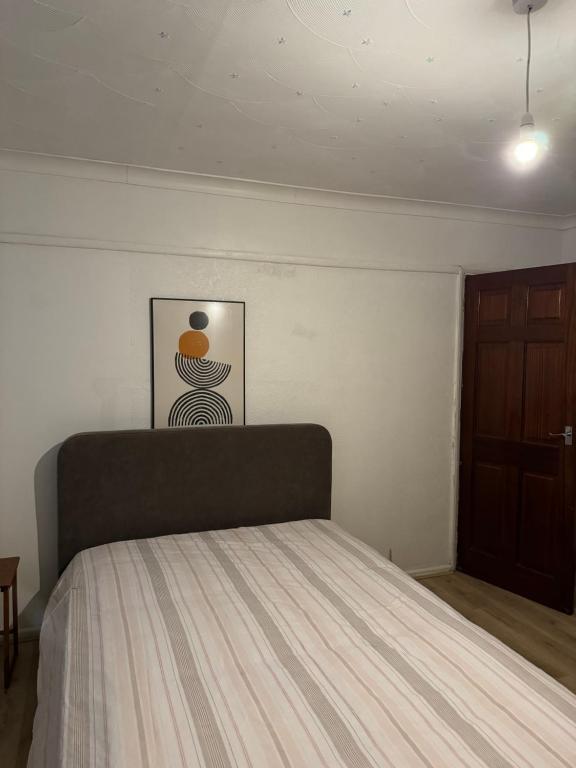 1 dormitorio con 1 cama y una foto en la pared en Double Rooms en Feltham