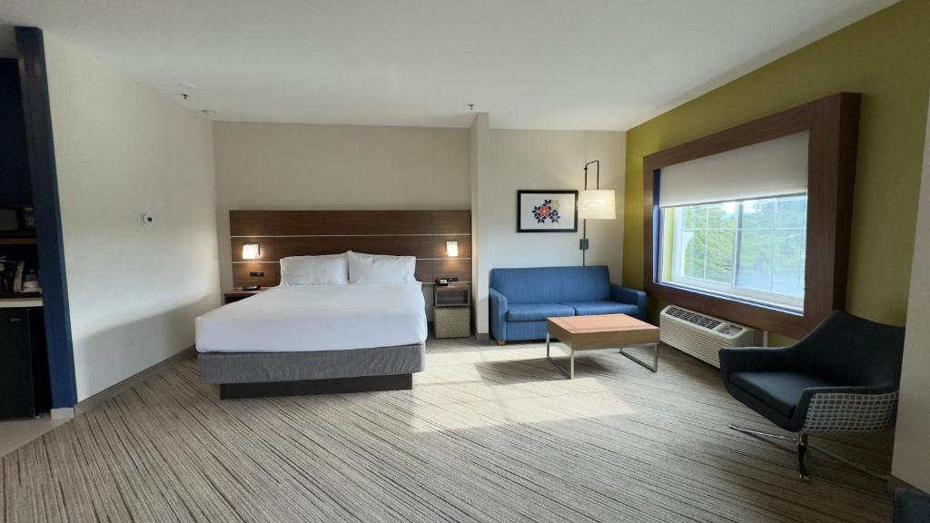 a hotel room with a bed and a blue chair at Holiday Inn Express Hotel & Suites Marina, an IHG Hotel in Marina