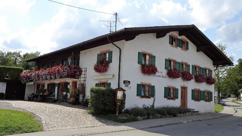 a white building with flowers on the side of it at Bäriger Urlaub mit viel Herz in Bad Bayersoien