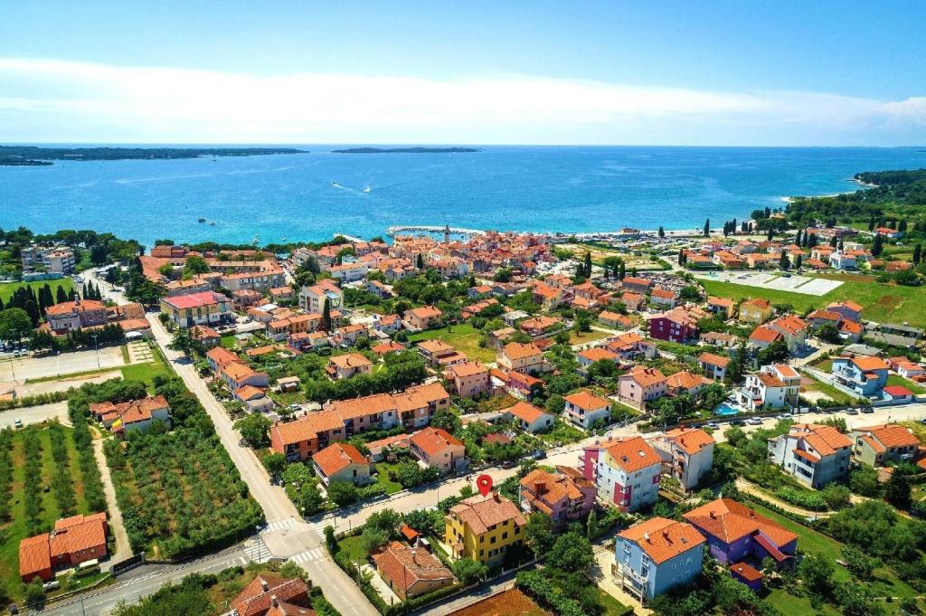eine Luftansicht einer Stadt neben dem Wasser in der Unterkunft Strandnahe Wohnung mit überdachter Terrasse und Garten in Fažana