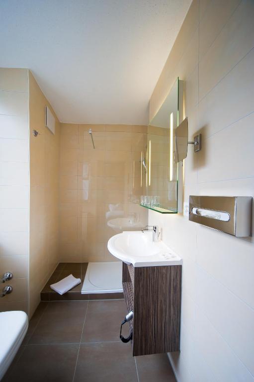 a bathroom with a sink and a toilet at Le Petit CHARME-INN in Zermatt