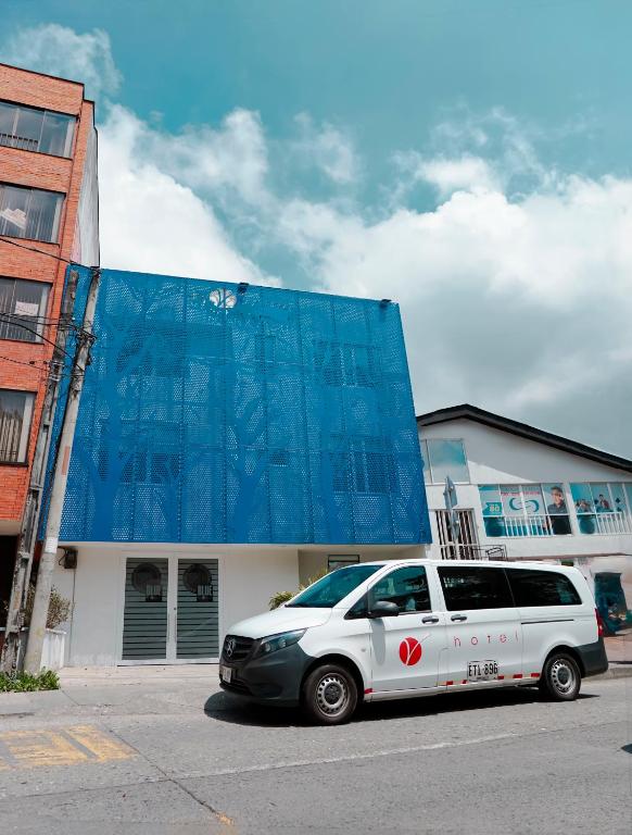 a white van parked in front of a building at Hotel Sky Blue in Manizales
