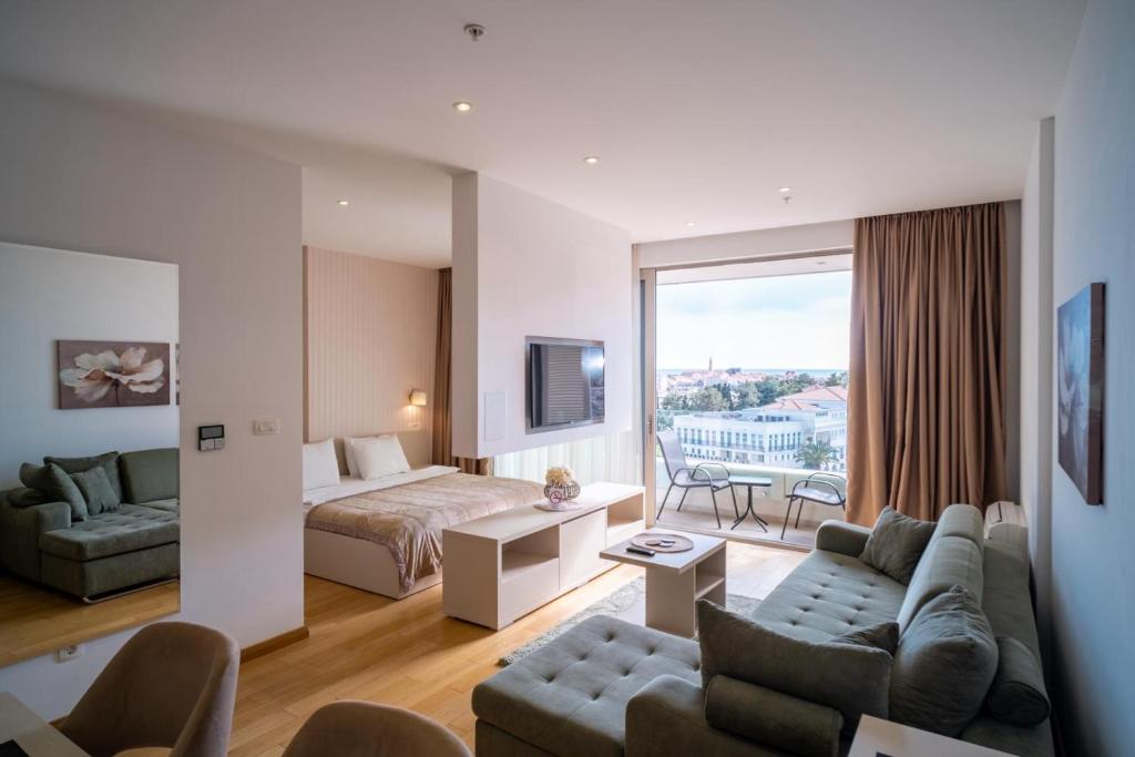 uma sala de estar com um sofá e uma cama em Budva Center Suite Old Town Sea Wiev 506 em Budva