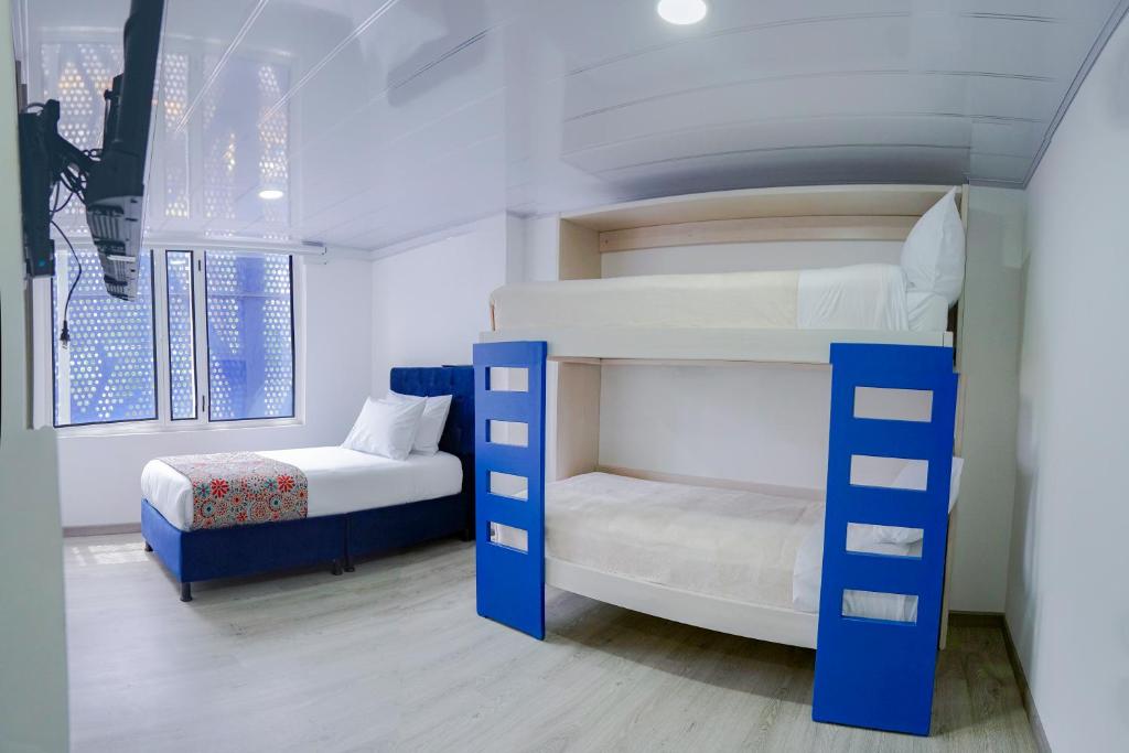sypialnia z 2 łóżkami piętrowymi i łóżkiem w obiekcie Hotel Sky Blue w mieście Manizales