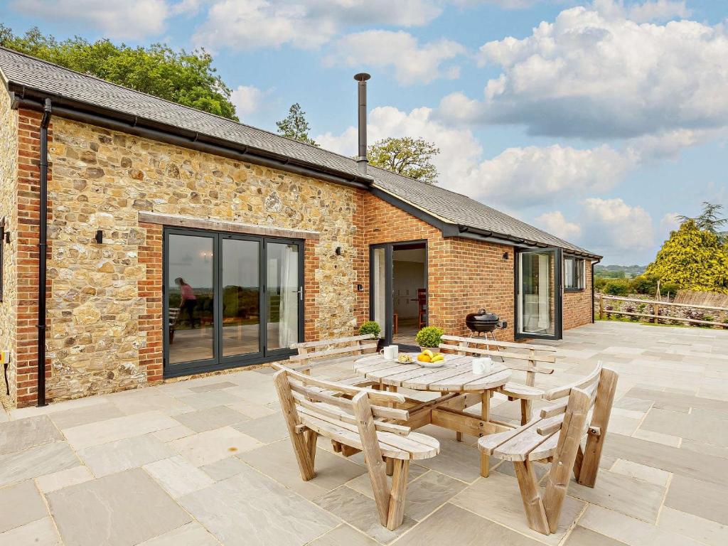 a brick building with a table and chairs on a patio at 4 Bed in Illminster 83501 in Combe Saint Nicholas