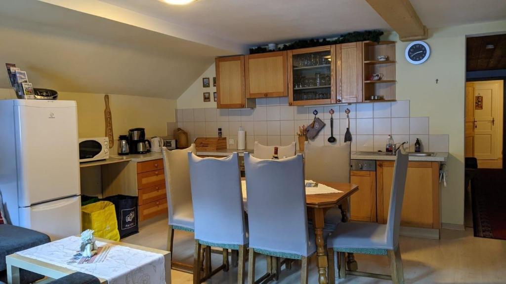 eine Küche mit einem Tisch und Stühlen sowie einem Kühlschrank in der Unterkunft Große Ferienwohnung in Nesselwängle in Nesselwängle