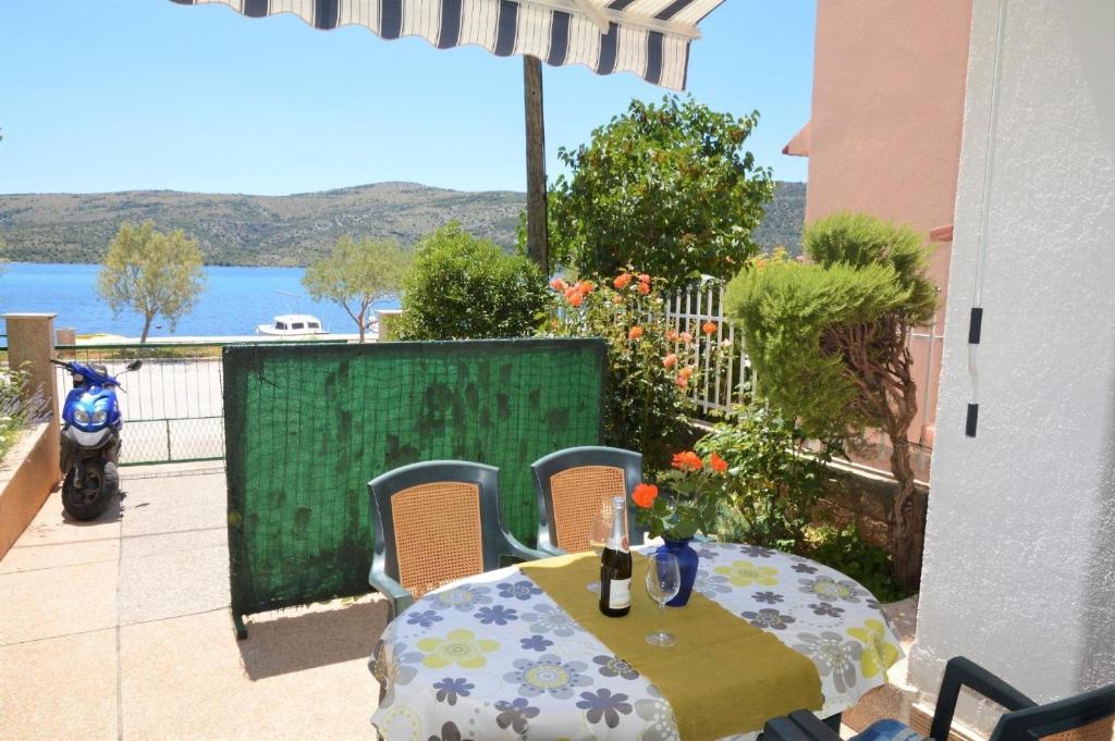 una mesa y sillas en un patio con vistas al agua en Ferienwohnung für 4 Personen ca 45 qm in Poljica bei Trogir, Dalmatien Kaštela und Umgebung, en Poljica