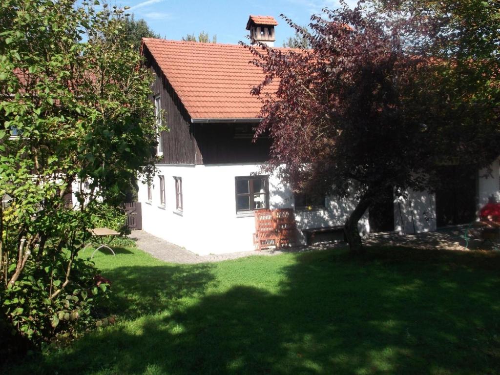 Casa blanca con techo rojo y patio en Ferienhaus für vier Personen mit Sitzgelegenheit, en Schöllnach