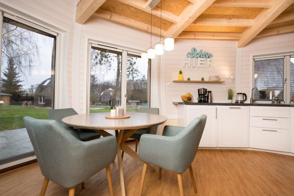 a kitchen and dining room with a table and chairs at Nordlichter - Kugelhaus am See in Penzlin
