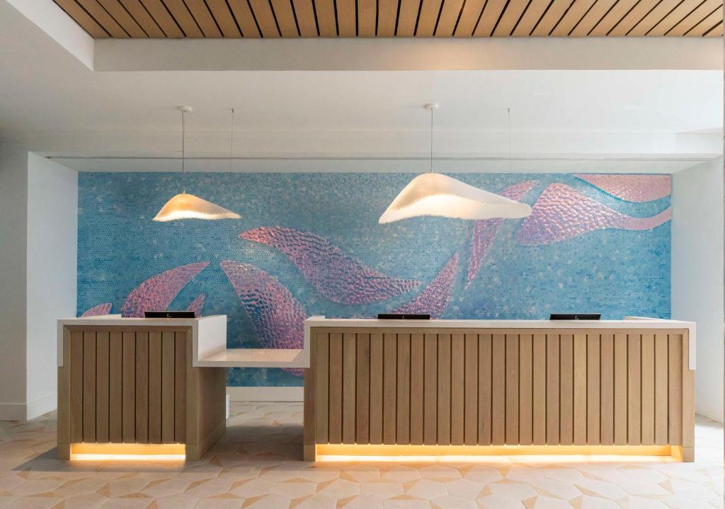 uma parede com uma grande pintura de peixes em The Singer Oceanfront Resort, Curio Collection by Hilton em Palm Beach Shores