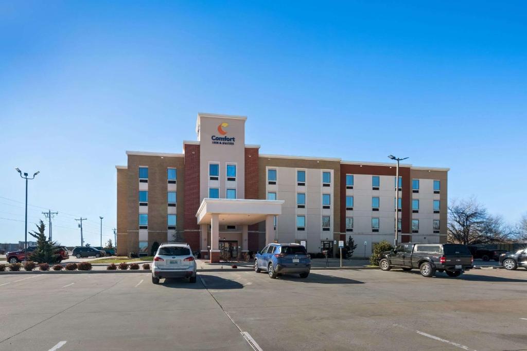 Comfort Inn & Suites Newcastle - Oklahoma City في Newcastle: مبنى كبير به سيارات تقف في موقف للسيارات