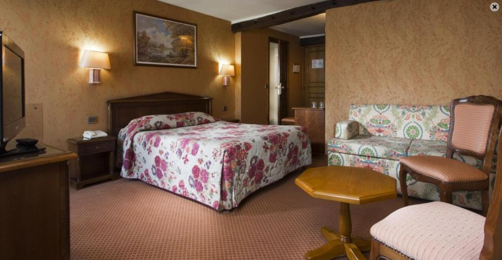 パリにあるホテル メレ レピュブリックのベッドルーム1室(ベッド1台、ソファ、椅子付)