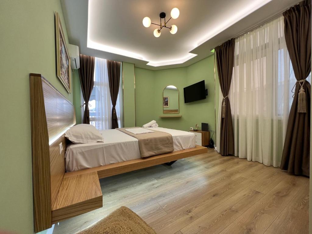a bedroom with a bed and a large window at Spiranca Apartments & Rooms in Tirana