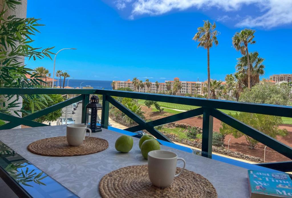 a table with two cups on a balcony with the ocean at Paz Ocean View, Air condition, Wifi, Heated pool in San Miguel de Abona