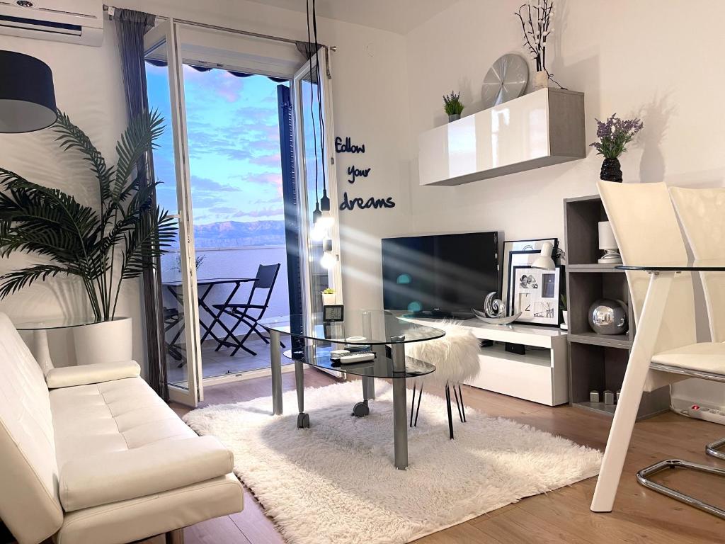 a living room with a glass table and a television at Apartment New Chic in Supetar