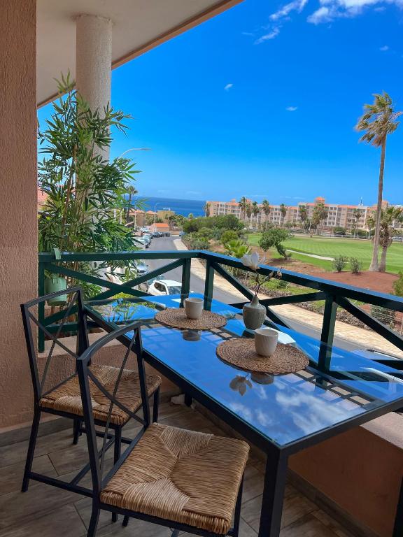 a blue table and chairs on a balcony with the ocean at Paz Ocean View, 2 Air Conditioners, Wifi, Heated pool in San Miguel de Abona