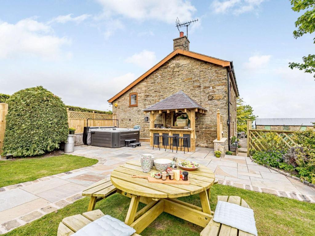 a garden with a wooden table and a building at 4 Bed in Holywell 82276 in Whitford