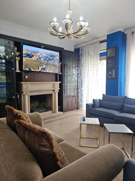 een woonkamer met een bank en een open haard bij Xplore Xpress • Penthouse in Tirana