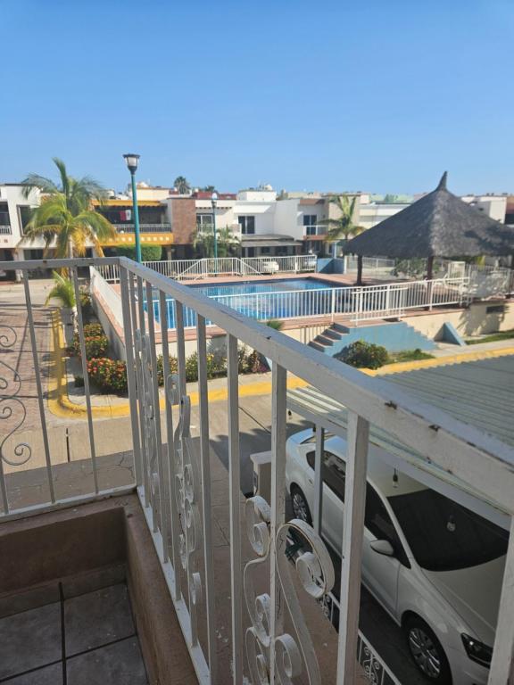 un balcón con un coche aparcado junto a una piscina en MAZATLÁN, Casa Completa 2 Pisos Residencial Rinconada, en Mazatlán