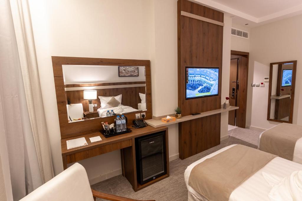 una camera d'albergo con letto e specchio di Wassad Hotel Makkah فندق وسد مكة a La Mecca