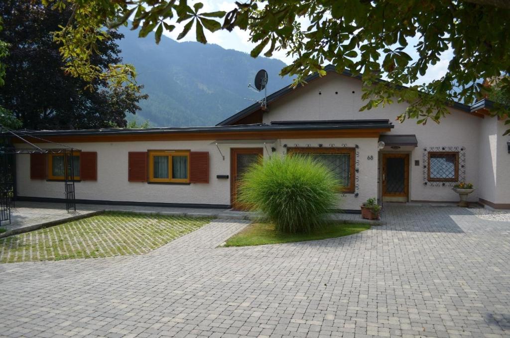 una casa blanca con una planta delante en Geräumige Ferienwohnung mit zwei Schlafzimmern, ideal für eine Familie, en Flattach