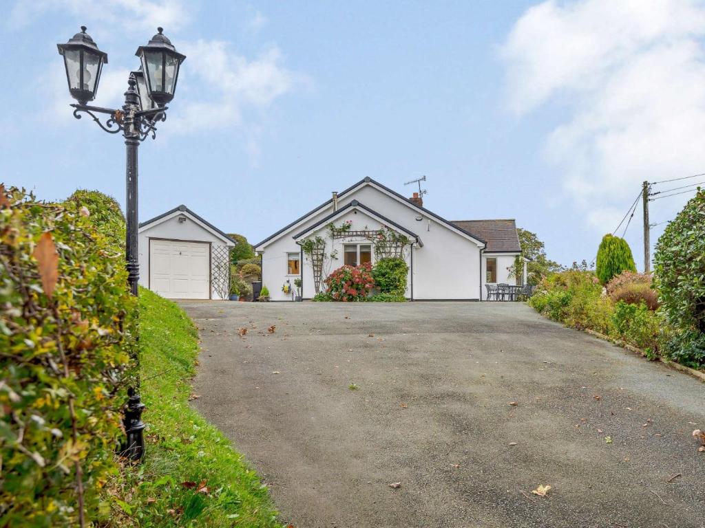 a house with a street light in front of a driveway at 3 Bed in Llanrhaeadr Ym Mochnant 85799 in Llanrhaeadr-ym-Mochnant