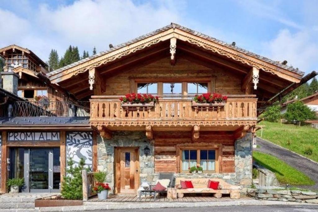ein Blockhaus mit einem Balkon auf der Vorderseite in der Unterkunft Komfortables Ferienhaus in Flachau mit Terrasse, Garten und Sauna und Panoramablick in Flachau