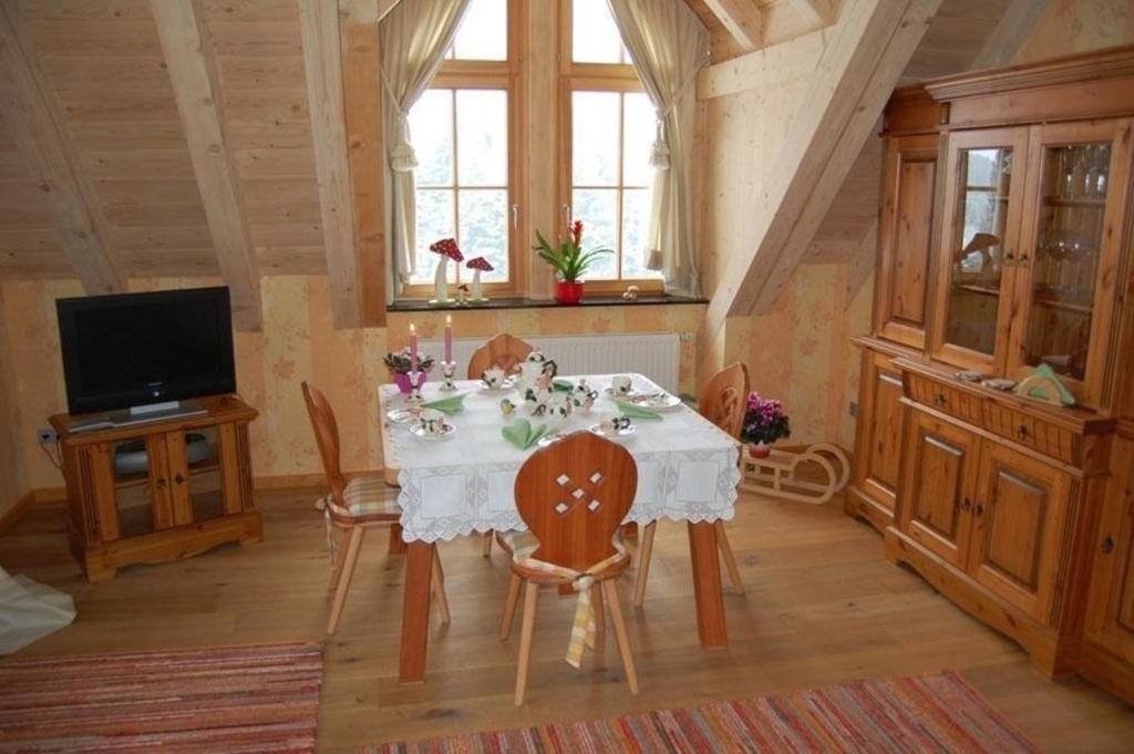 a dining room with a white table and chairs at Liebevoll eingerichtete Ferienwohnung auf der zweiten Etage mit Balkon in Schönwald
