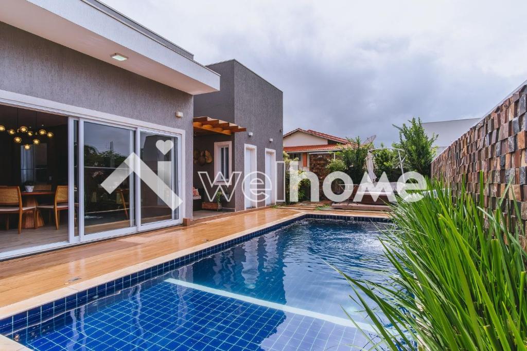 a swimming pool in front of a house at Casa em condomínio com piscina em Pardinho in Pardinho