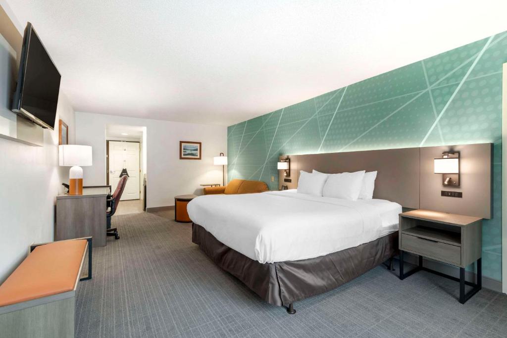 Habitación de hotel con cama grande y escritorio. en Comfort Inn & Suites en Lake George