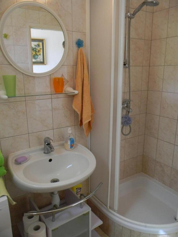 łazienka z umywalką, prysznicem i lustrem w obiekcie Apartments Gabriel w Nin