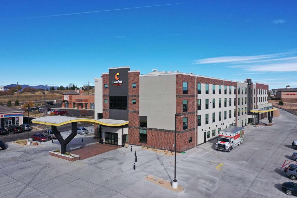 un gran edificio con una estación de autobuses en un aparcamiento en Comfort Suites Colorado Springs East - Medical Center Area en Colorado Springs