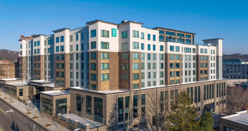 a large white building with windows on a city street at Embassy Suites By Hilton Asheville Downtown in Asheville