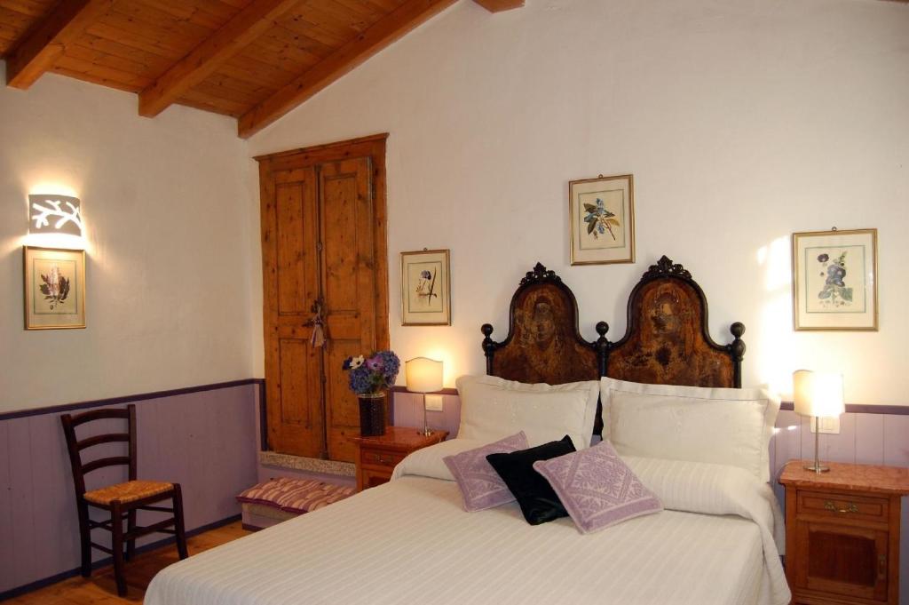 a bedroom with a bed with white sheets and purple pillows at Gästezimmer für 2 Personen 1 Kind ca 30 qm in Loiri Porto San Paolo, Sardinien Gallura in Biacci